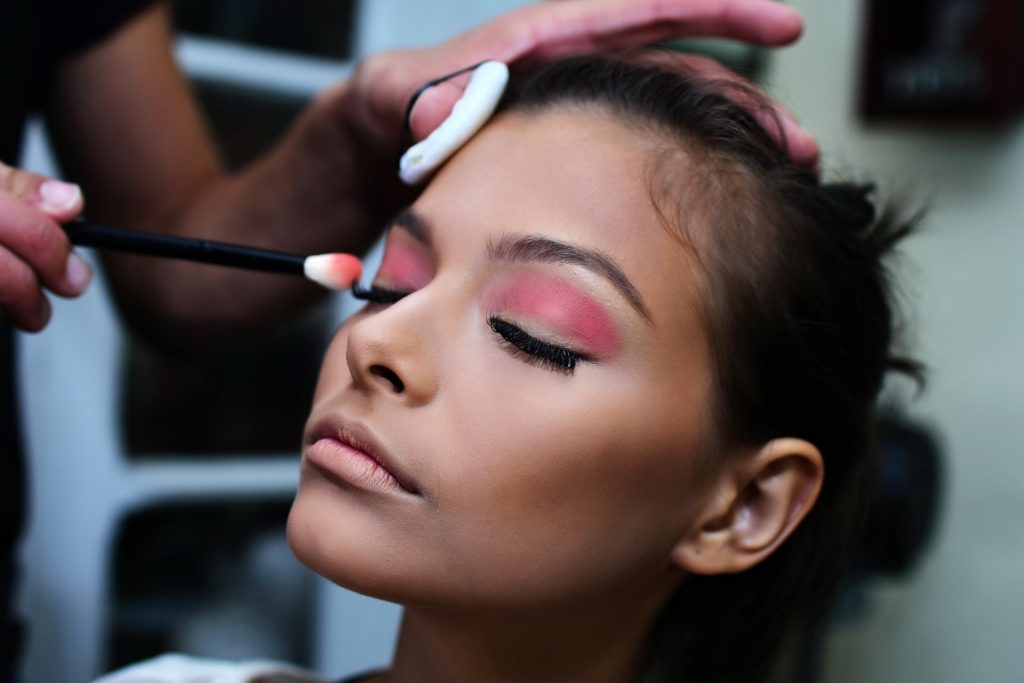 A makeup artist applying makeup on a model's face
