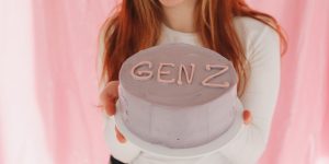 Young Gen Z girl holding a cake, showing that Gen Z has skills and knowledge we can only be jealous of